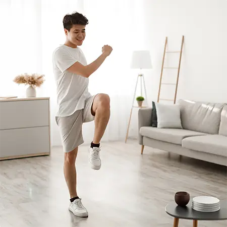 jeune homme exécutant un mouvement de Brain Gym dans son salon