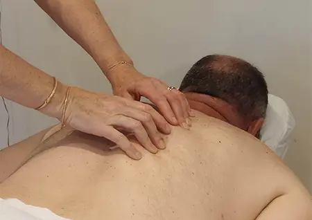 Homme allongé sur une table de massage pour une séance de NST Bowen